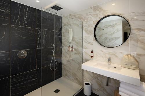 uma casa de banho com um lavatório e um espelho em Les Nomades Beaune em Beaune