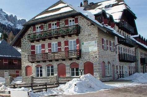 a large building with snow on the ground in front of it at SUITE25 GOLFHOTEL in Carezza al Lago