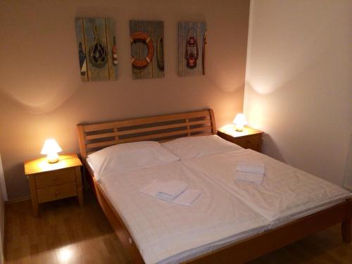 a bedroom with a bed with two lamps on it at Apartmán Adam in Lipno nad Vltavou