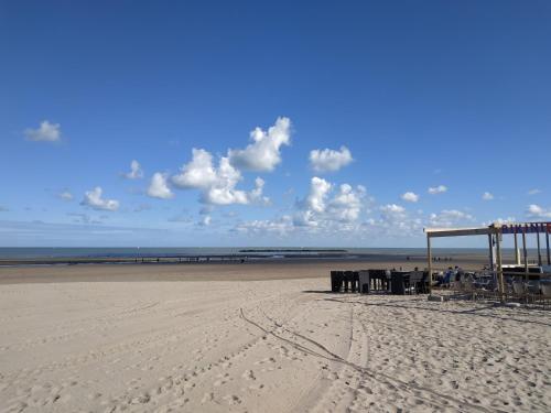 a beach with a gazebo and chairs on it at Sea view & Beach Studio Apartment - Blue Horizon in Dunkerque