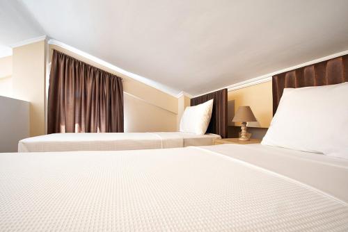 a hotel room with two beds and a window at Valery Apartments in Pefkohori