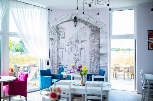 un restaurante con mesas y sillas y un mural en la pared en Wyjątkowe Smaki, en Pruszcz Gdański