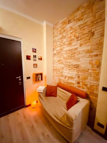 un soggiorno con divano e muro di mattoni di Casa Vacanze La Casetta a Lido di Ostia