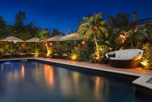 a swimming pool at night with chairs and umbrellas at Salvaterra Country House & SPA in Salvaterra de Magos