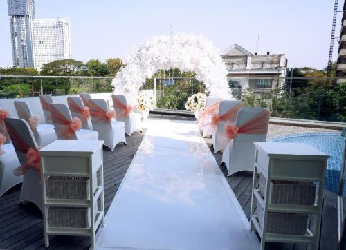 a white table with chairs and an arch with flowers at HARRIS Hotel & Conventions Bundaran Satelit Surabaya in Surabaya