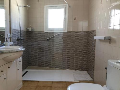 een badkamer met een douche, een toilet en een raam bij Lanzarote - El Golfo in El Golfo