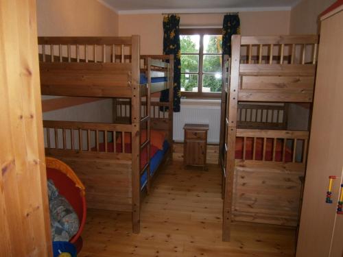 a room with four bunk beds and a window at Five Oaks - Weisse Wohnung in Hohenkirchen
