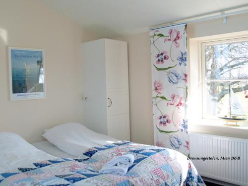 a bedroom with a bed and a window with flowers at Tiendegaarden Møns Klint in Borre