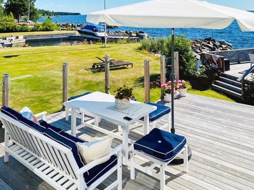 a table with chairs and an umbrella on a wooden deck at 4 person holiday home in NORRSUNDET in Norrsundet