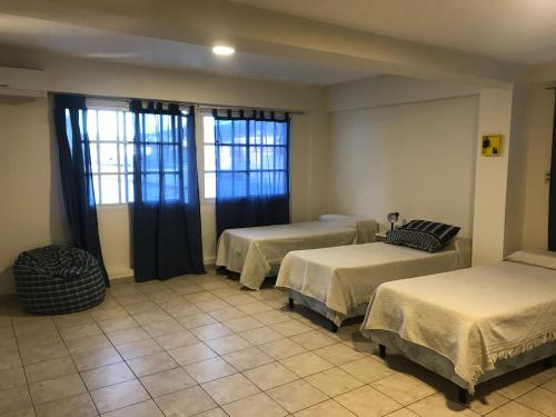 Habitación con 3 camas y 2 ventanas en Belgrano 9, en Salta