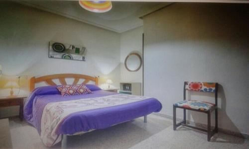 sypialnia z fioletowym łóżkiem i krzesłem w obiekcie Apartamento en Torrevieja a 50m playa w mieście Torrevieja