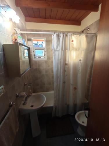 een badkamer met een wit douchegordijn en een wastafel bij Hogar Argentina in Quilmes