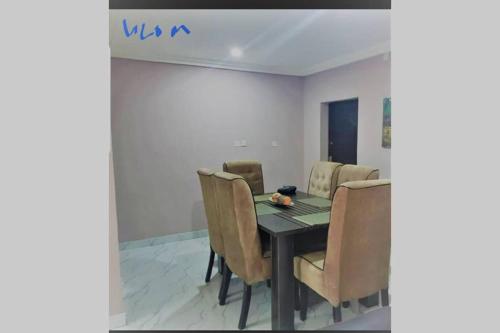 - une salle à manger avec une table et des chaises dans l'établissement ULOM 1condos apartment, à Owerri