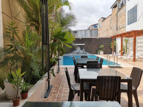 モヨバンバにあるMurano Hotelの屋外パティオ(テーブル、椅子付)、スイミングプールを提供しています。