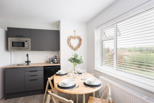 a kitchen with a table and a heart decoration on the wall at River Retreat Apartment Exeter - River Views & Parking in Exeter
