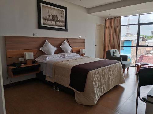 een hotelkamer met een bed en een groot raam bij Murano Hotel in Moyobamba