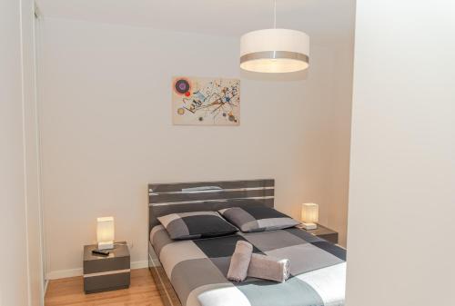 a bedroom with a large bed with two lamps at Le Victoria hyper-centre Décines in Décines-Charpieu