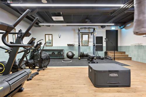 a gym with a treadmill and bikes in a room at Hotel Giò; BW Signature Collection in Solna