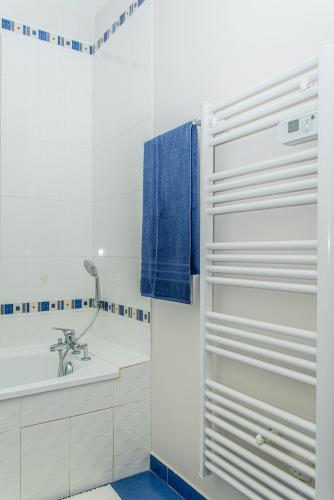 a bathroom with a white tub and a sink at Le Victoria hyper-centre Décines in Décines-Charpieu