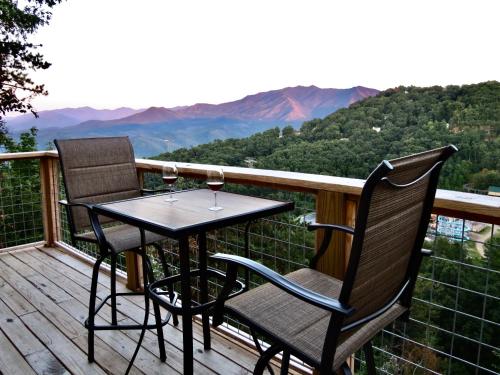 a table and two chairs on a deck with wine glasses at Million Dollar Views! 4 Bedroom, Sleeps 9, close to National Park and 5 mi to Gatlinburg! in Gatlinburg