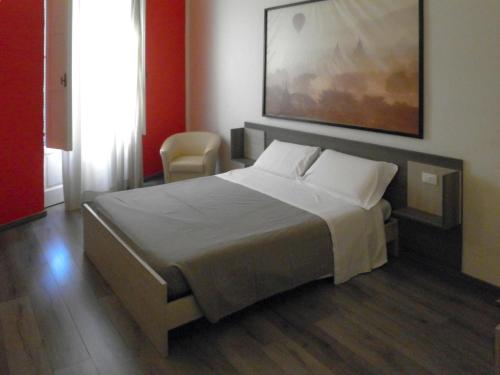 um quarto com uma cama e um quadro na parede em IL TRULLO Modern Rooms em Brindisi