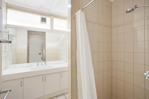 a bathroom with a sink and a shower at Penguin Mews Merimbula in Merimbula