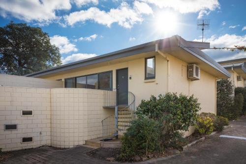a house with the sun shining behind it at Penguin Mews Merimbula in Merimbula
