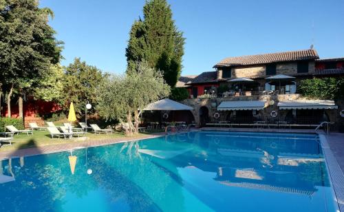 una grande piscina di fronte a una casa di Casanova - Panoramic Rooms and Suites a San Quirico dʼOrcia