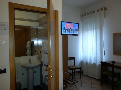 サン・ジョヴァンニ・ルパトートにあるAlbergo Pizzeria Soleのバスルーム(洗面台付)、壁掛けテレビが備わります。
