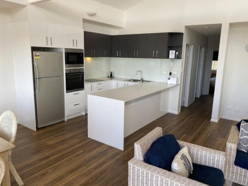 a kitchen with white cabinets and a white counter top at Aqua Promenade Beachfront Holiday Apartments in Sunrise Beach