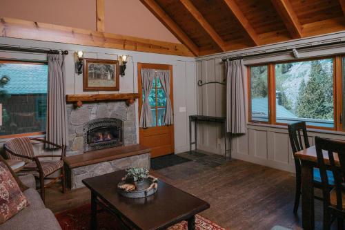Tamarack Lodge في بحيرات ماموث: غرفة معيشة مع موقد وطاولة