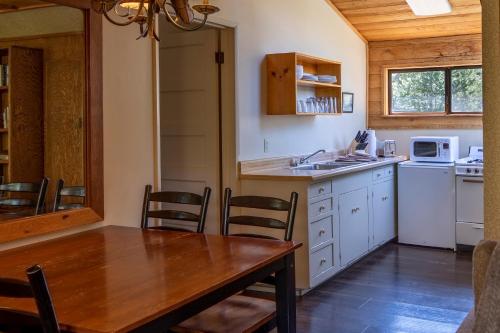 a kitchen with a table, chairs and a refrigerator at Tamarack Lodge in Mammoth Lakes