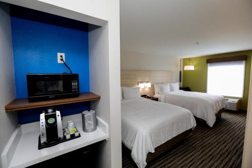 a hotel room with two beds and a flat screen tv at Holiday Inn Express Hillsboro I-35, an IHG Hotel in Hillsboro