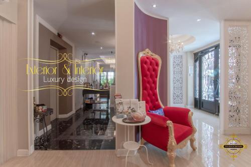 a living room with a red chair and a table at The Star of Sathorn in Bangkok