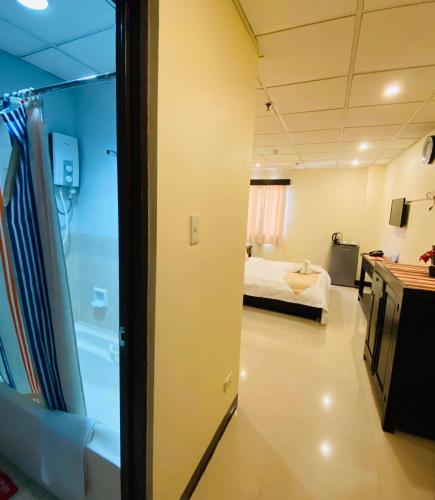 a room with a bed and a bathroom with a tub at Amax Inn Makati in Manila
