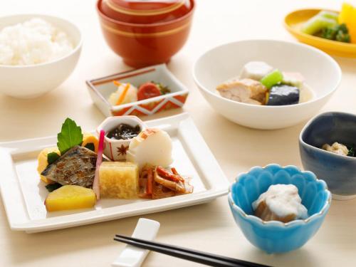 a table topped with plates of food and bowls of food at ANA Holiday Inn Kanazawa Sky, an IHG Hotel in Kanazawa