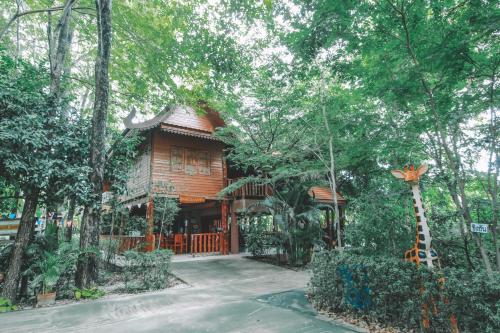 a wooden house with a giraffe in front of it at Akchanok Homestay in Phitsanulok