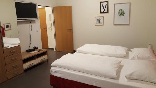 a bedroom with two beds and a tv on the wall at City Center Apartments Linz in Linz