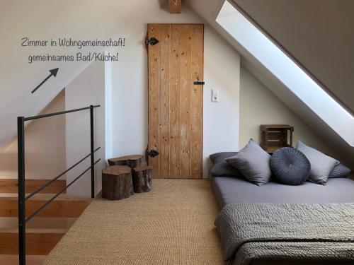 a attic room with a bed and a door at Privatzimmer Leopold in Sigmaringen