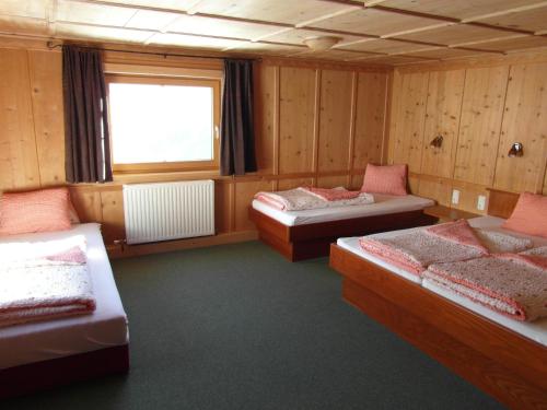 a room with three beds and a window at Ferienhaus Nadine in Kappl