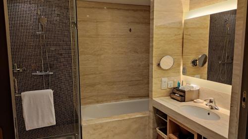 a bathroom with a shower and a sink and a tub at Marco Polo Parkside, Beijing in Beijing