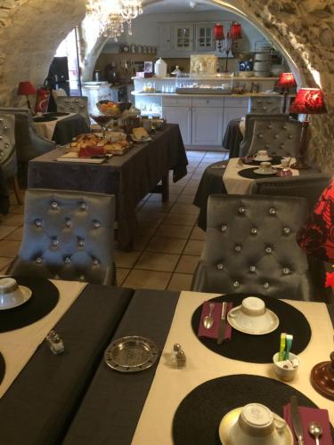 a restaurant with tables and chairs with food on them at Hotel Le Saint Laurent in Saint-Laurent-des-Arbres