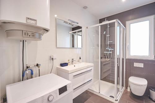 une salle de bain blanche avec une douche et un lavabo dans l'établissement FranceComfort - Village des Cigales, à Mauroux