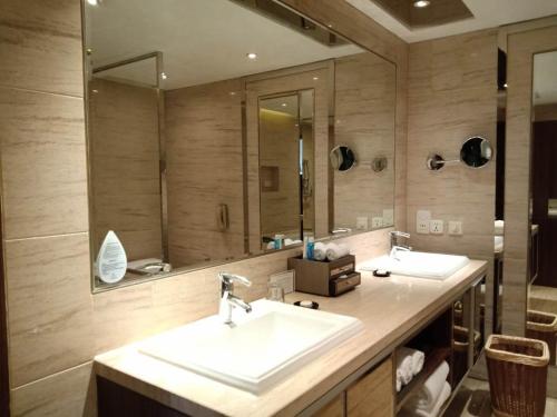 a bathroom with two sinks and a large mirror at Marco Polo Parkside, Beijing in Beijing
