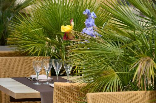 a table with wine glasses and flowers on it at Logis Hôtel & Restaurant Le Pardaillan in Gondrin