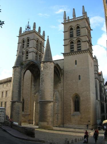 an old church with two towers on a street at Kyriad Hotel Montpellier Centre Antigone in Montpellier
