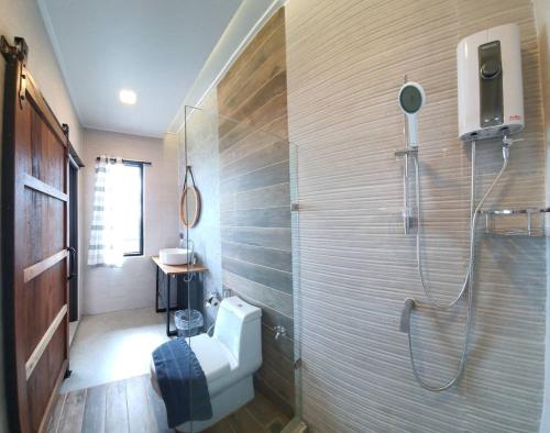 a bathroom with a shower and a toilet in it at At Tree Resort Khaokho in Khao Kho