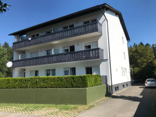 a white building with a balcony on top of it at Apartementhaus Helene am Klopeinersee in Unterburg am Klopeiner See