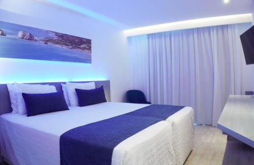 a bedroom with a large bed with blue lighting at Anonymous Beach Hotel (Adults 16+) in Ayia Napa