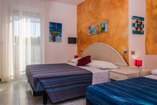1 dormitorio con 2 camas y ventana en Hotel Nuova Graziosa, en Lignano Sabbiadoro